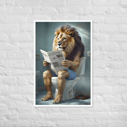 Framed artwork of a lion sitting on a toilet reading a newspaper against a white brick wall.